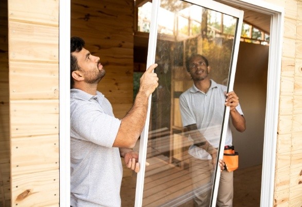 Workers installing a sliding glass window pane